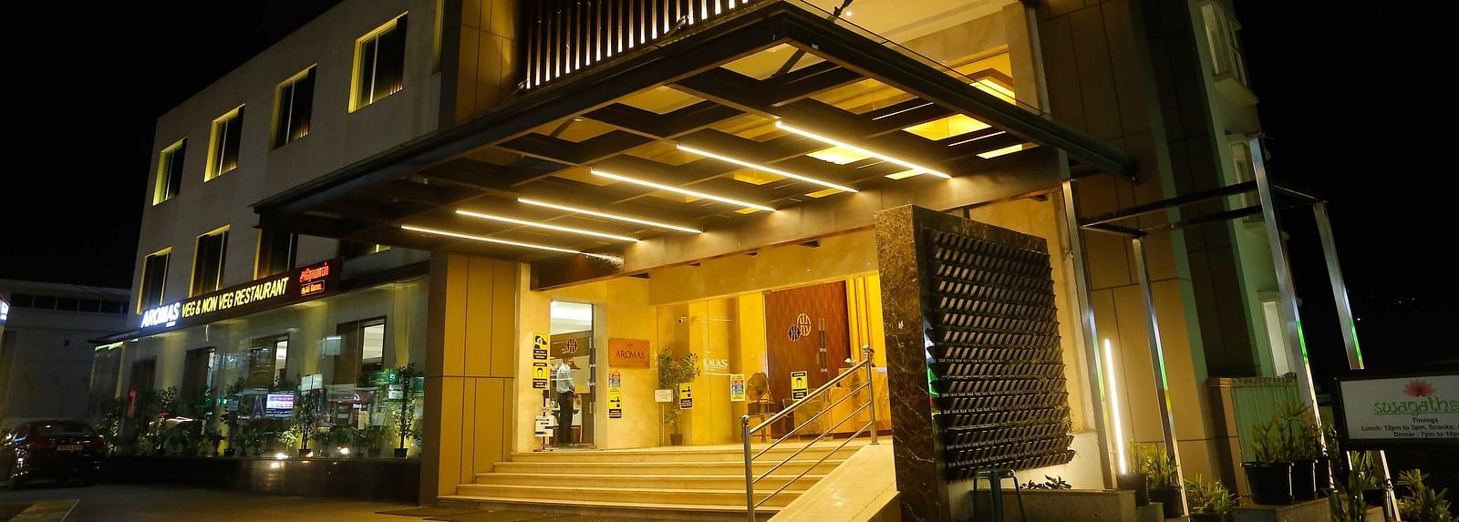 Exterior view of The Hamuse Hotel, Kodaikanal at night, brightly lit with the hotel name displayed prominently on the facade.