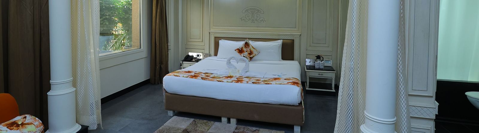 overview  image of a Suite at Amar Hotel with a bed, table, sofa and a window