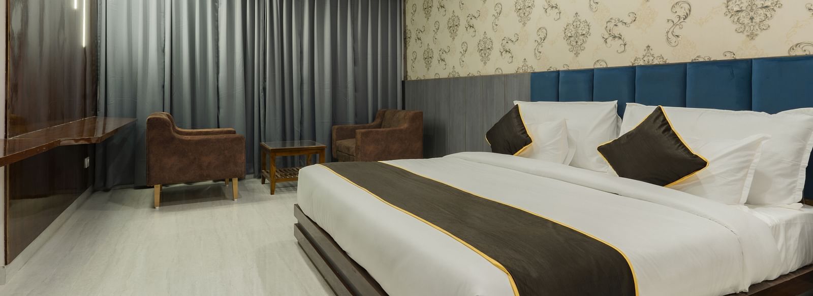 A bedroom at the Bamboo Saa Mulberry Resort, Pushkar featuring a bed with white linens and decorative pillows.