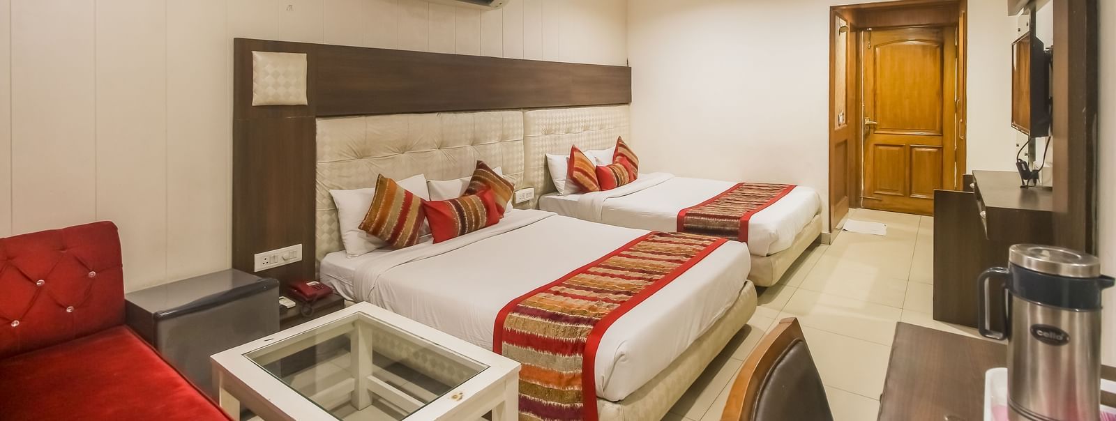 Twin bedded room with lounge seating and modern decor at Hotel Diamond Plaza, Chandigarh