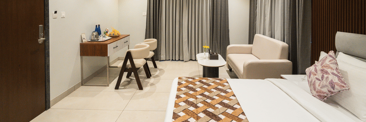 A hotel room with a double bed a work desk and a sofa  - MGM Whispering Meadows