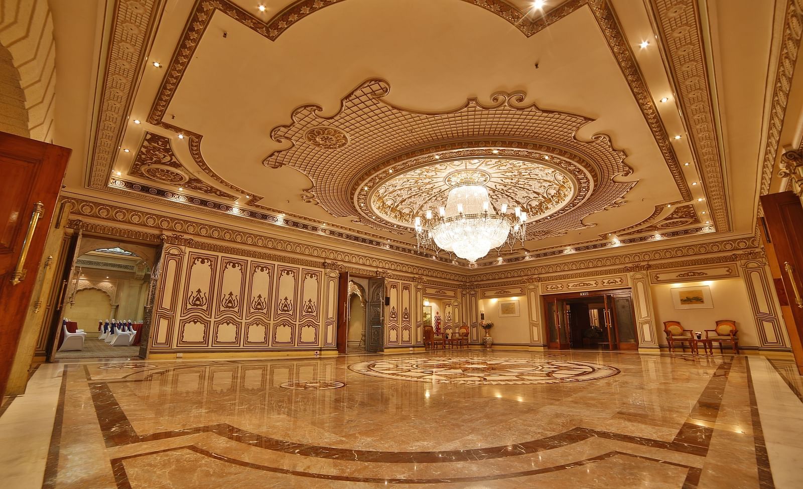  Interiors of Rang Mahal hall A grand hotel suite with an opulent red and white decor, large bed, and seating area, reflecting a traditional style at Sitara Luxury Hotel in Hyderabad near Ramoji Film City.