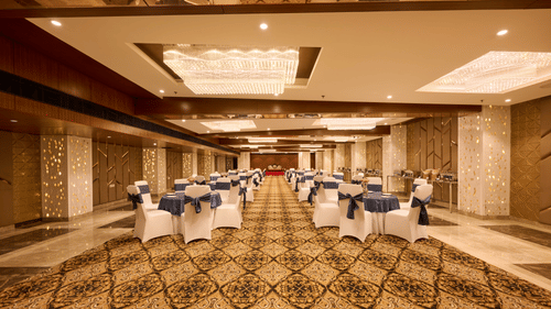 A banquet hall at our hotel with chairs and carpeted flooring