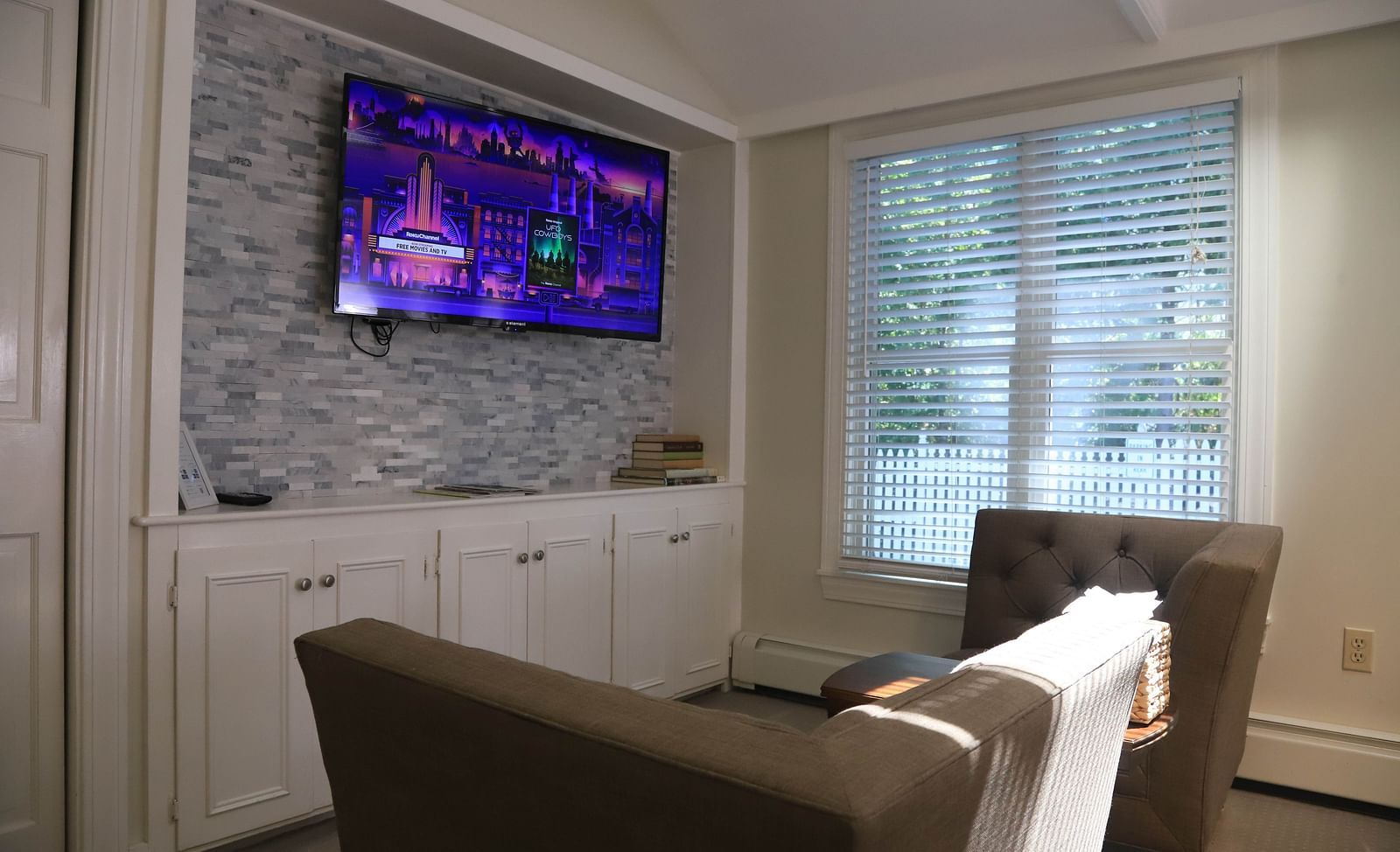 Seating area with chairs and mounted TV at Hartstone Inn.