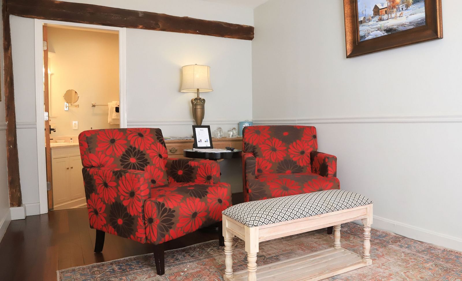 Seating area with two red patterned chairs and a table at Hartstone Inn.
