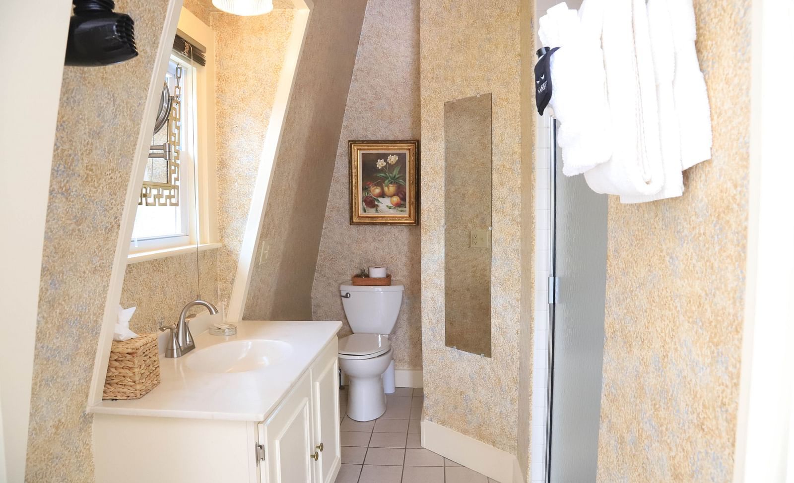 Elegant bathroom with vanity and slanted ceiling at Hartstone Inn