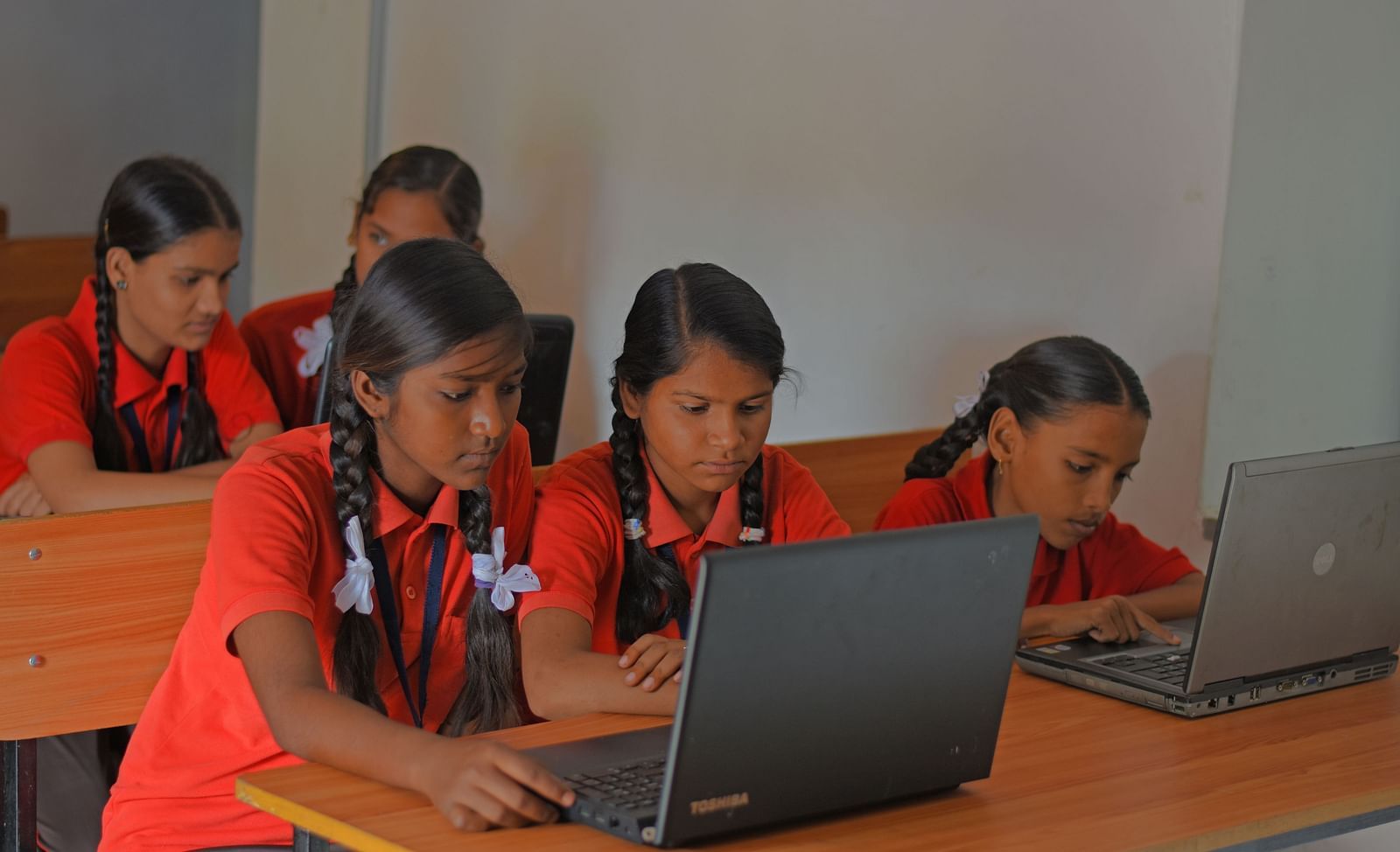 An image of two girls looking into the laptop- Shahpura Bagh.