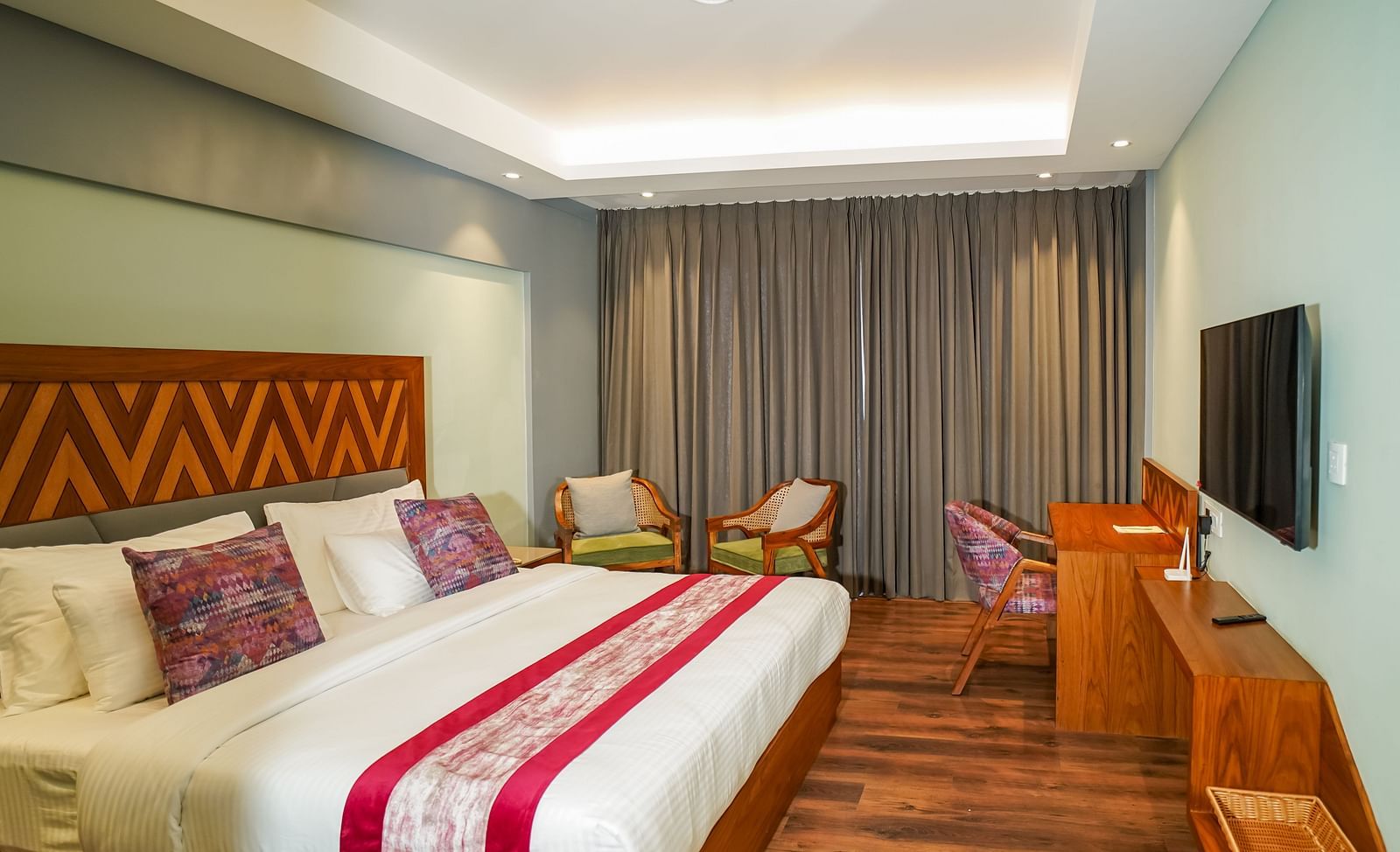 A hotel bedroom with a large bed, bedside tables, and warm lighting | Deluxe Room with Himalayan View | Sukama Resort & Spa, Nainital