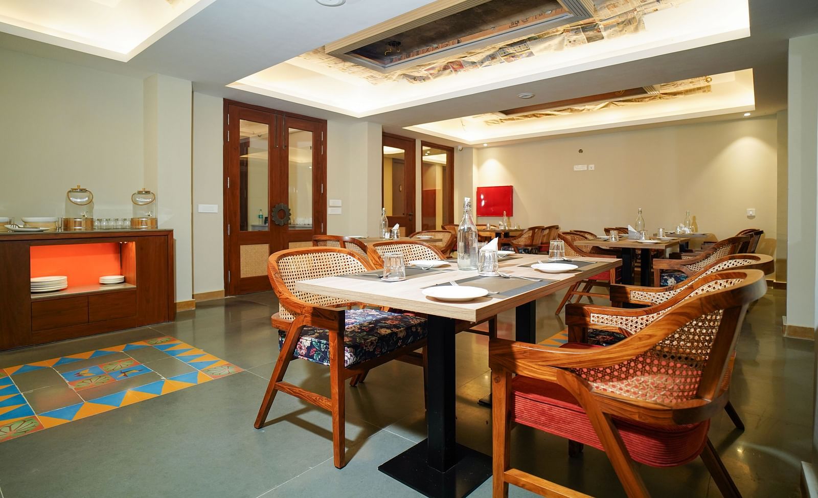 A dining room with several tables and chairs, a fireplace, and a large window | Sukama Resort & Spa, Nainital