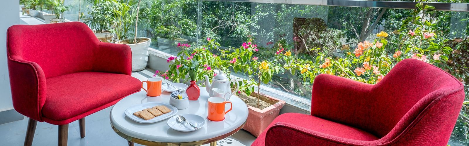 An image of a sitting area at the balcony with one centre table and two chairs | Inde Hotel Golf Course Extension