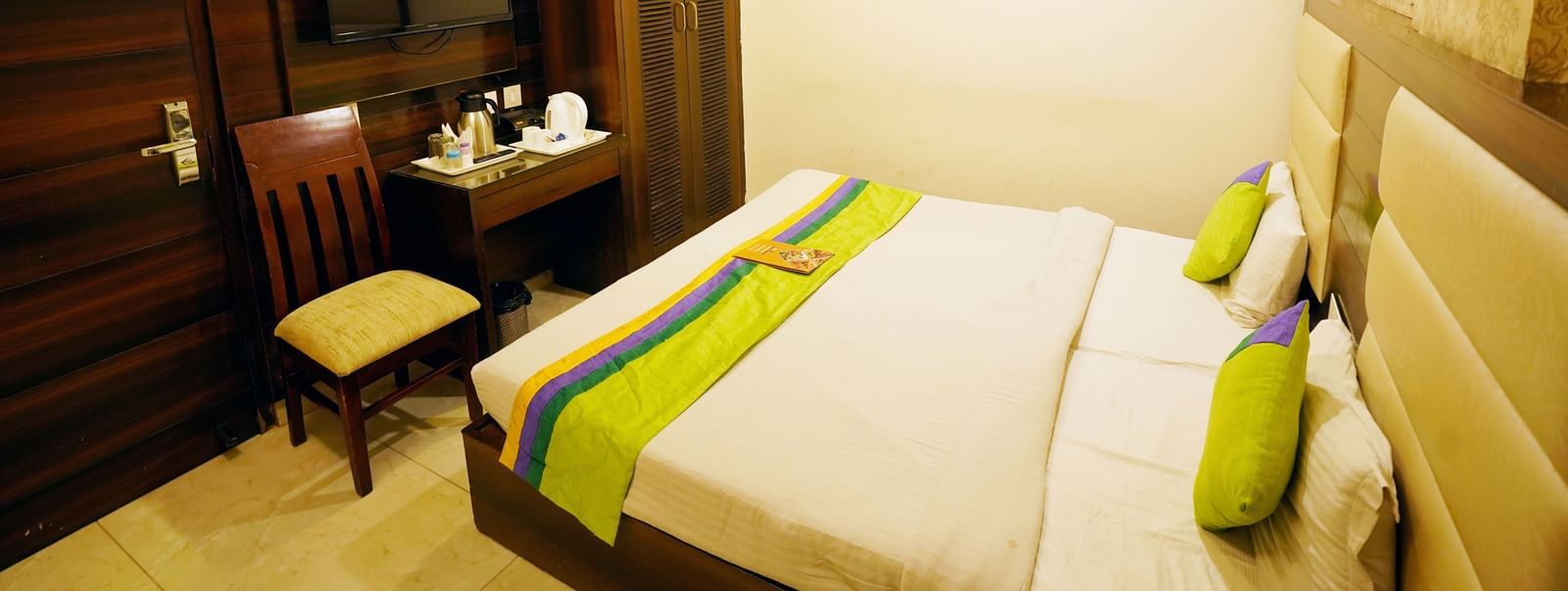 Well-lit view of Standard Room with King-size bed facing a TV, wooden wardrobe, air-conditioning and marble-flooring at  Hotel Dreamland, Chandigarh