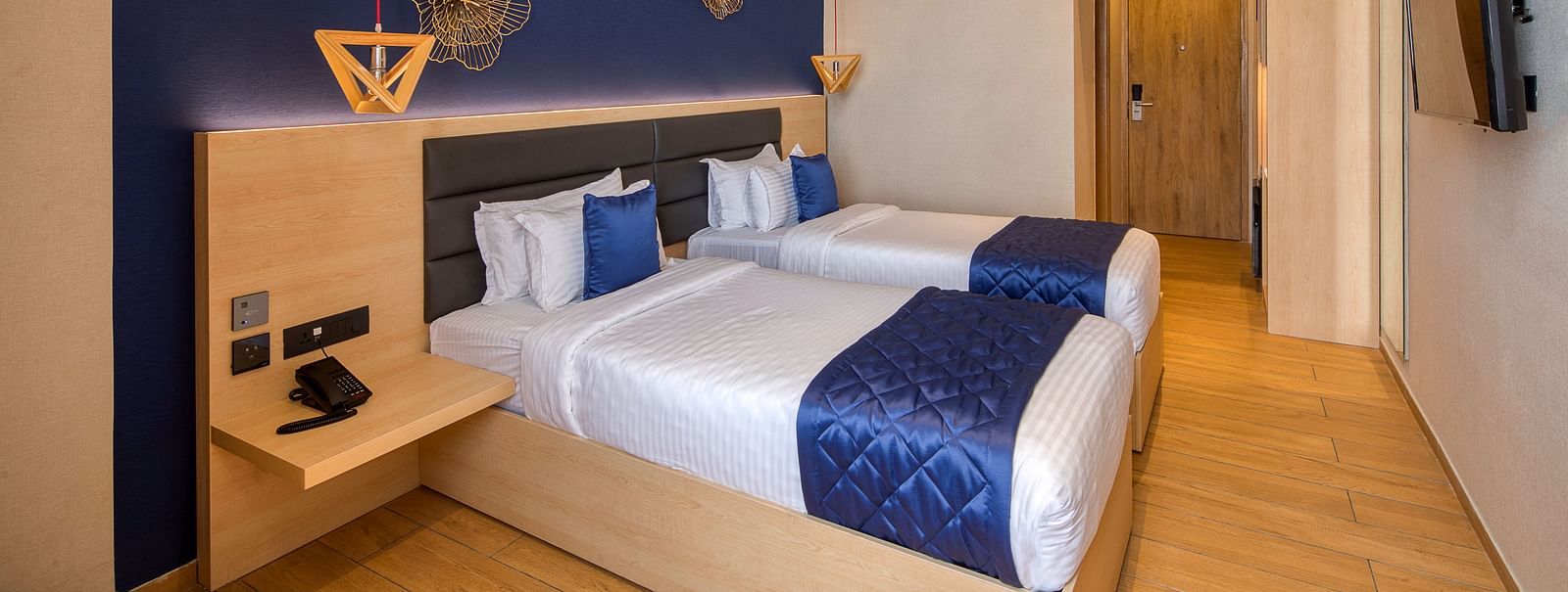 Twin beds with blue bedsheets and pillow covers at Executive Room at Le Foliage by TGI, Bangalore 2