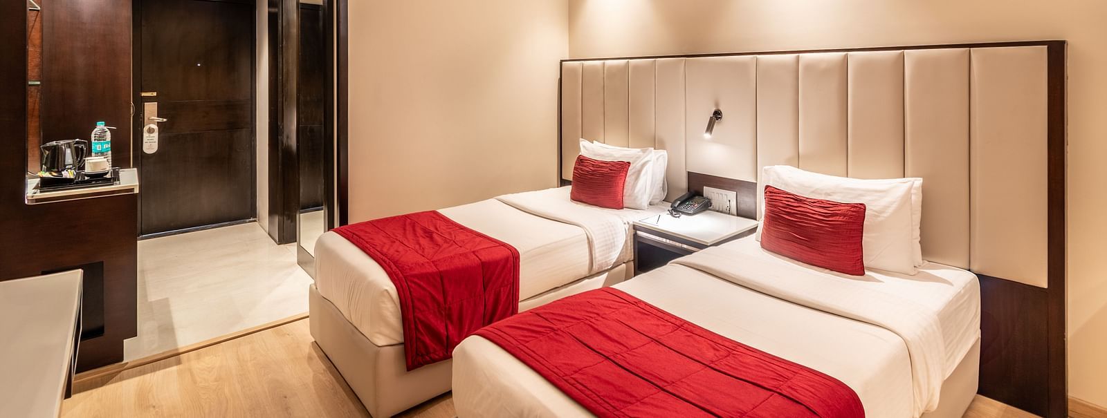 Superior Room with two beds featuring patterned bedding, a desk area, and lighting- TGI Grand Fortuna, Krishnagiri Main Road, Hosur