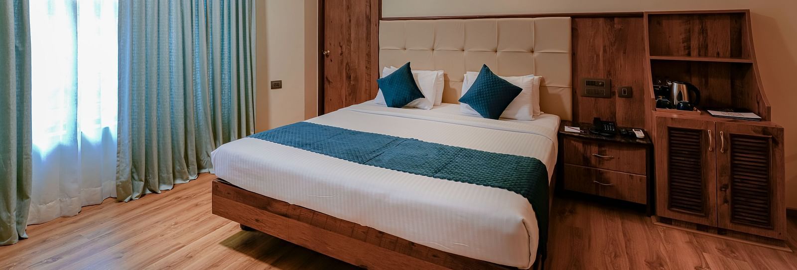 A spacious room in J. P. Nagar featuring a queen size bed,  modern amenities, and soft lighting - Cross Roads Inn, Bengaluru