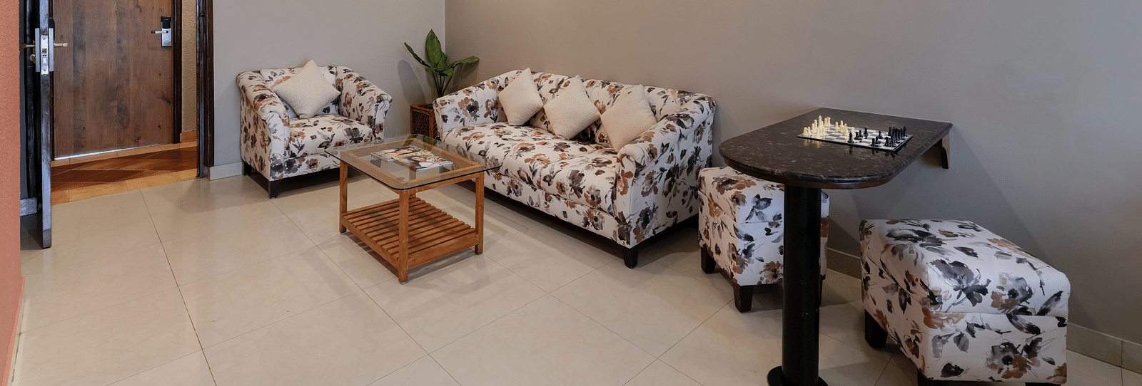 A spacious seating area in our Suite with a patterned sofa set - Cross Roads Inn, Bengaluru