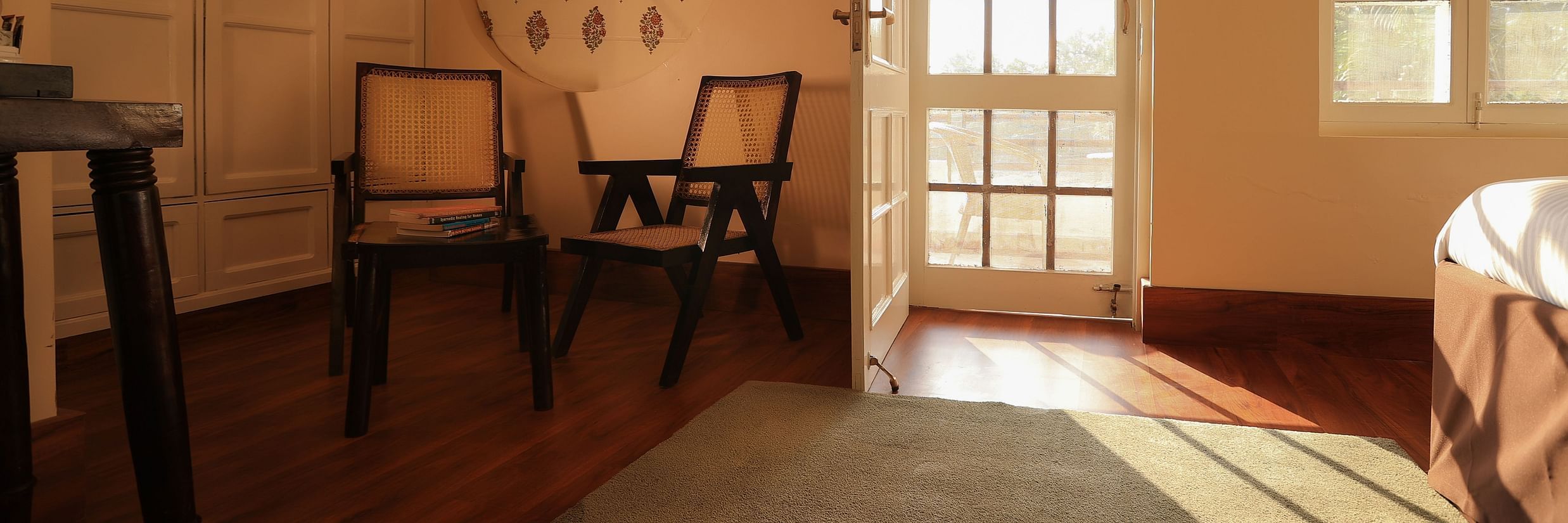 Super deluxe room is equipped with chairs and a glass door that opens to the balcony2 - Lamrin Boutique Cottages Rishikesh