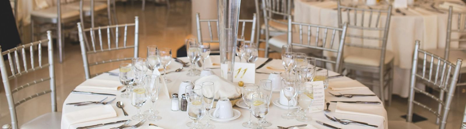 Classically decorated wedding reception table with lush white floral arrangements