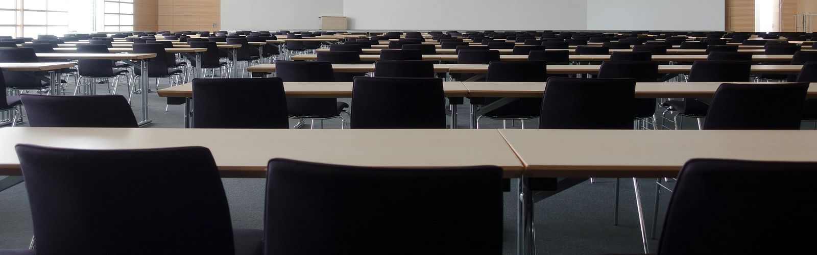 an image of conference hall with chairs and tables 