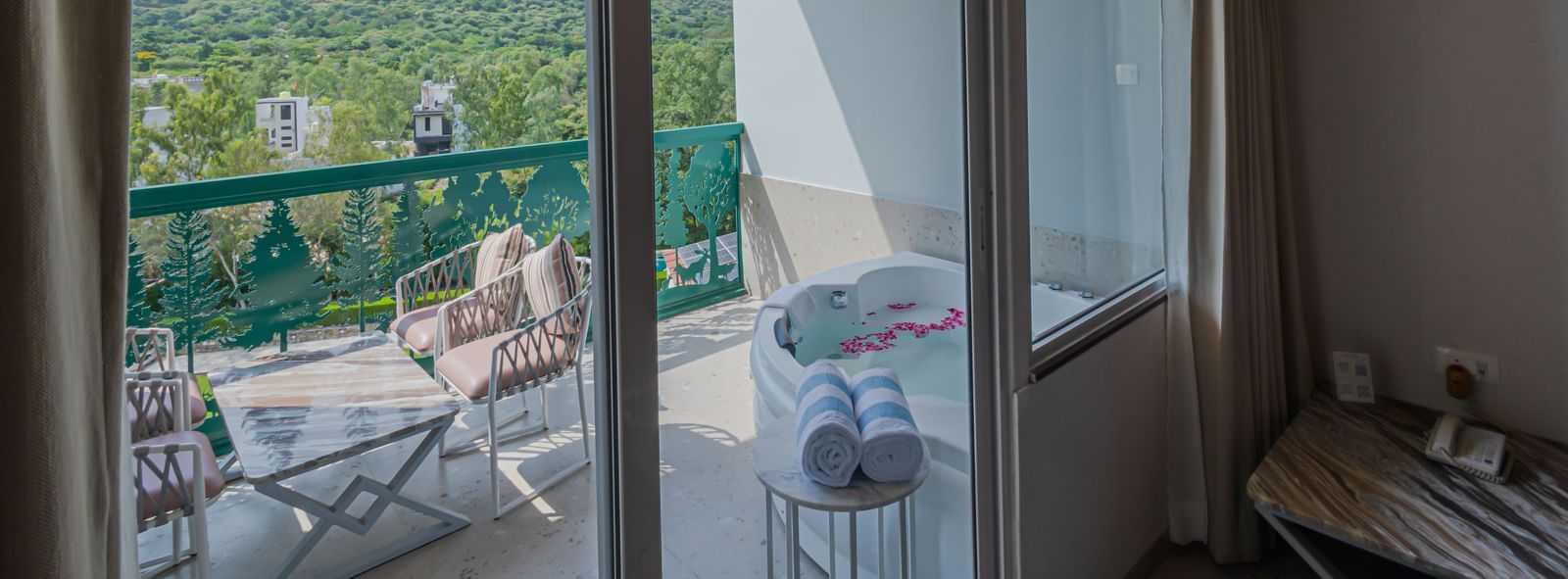 A view of the balcony from Sajjan Villa at Bamboo Saa Resort and Spa, Udaipur showcasing seating area and a jacuzzi.