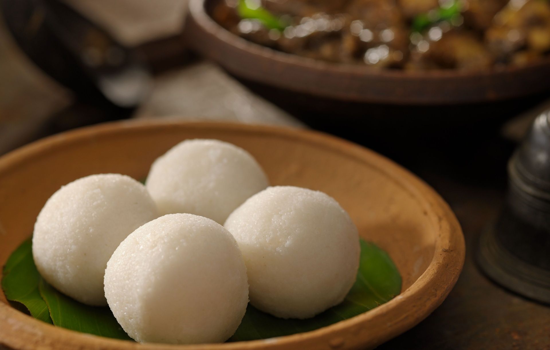 Four Coorg steamed rice balls (Kadamputtu) with curry.