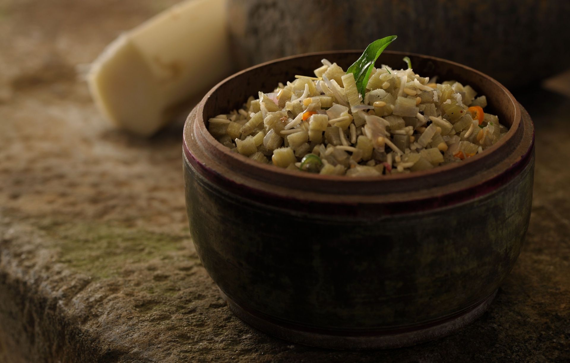 Bowl of banana stem and lentil dish with vegetables.