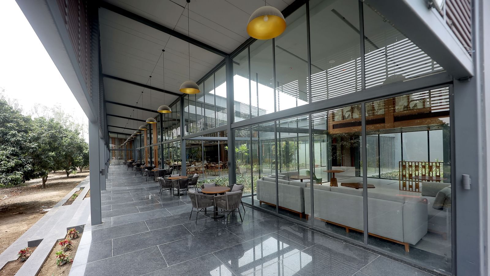 Spacious glass corridor with polished floors and natural light flowing through high windows at Wyndham Garden.