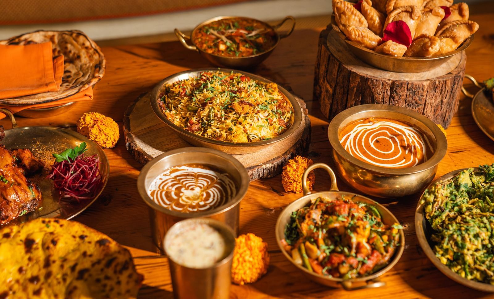 A festive Holi feast by Dhaba, featuring a delicious spread of traditional food, beautifully presented on a rustic wooden table