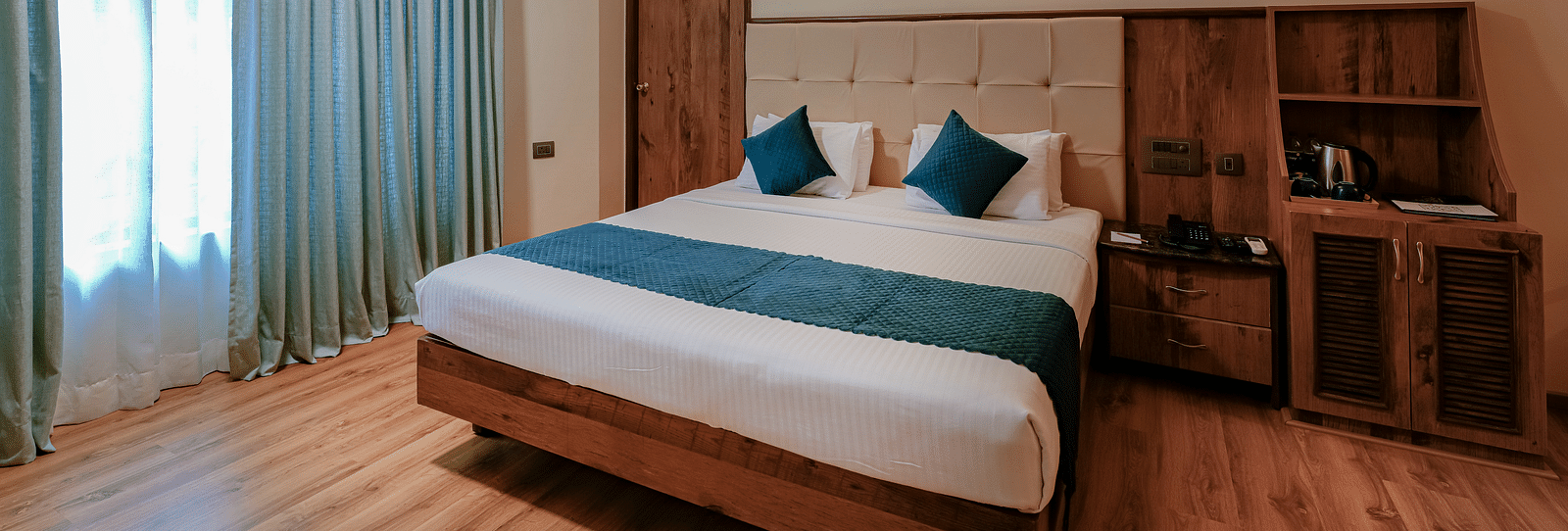 A spacious room in J. P. Nagar featuring a queen size bed,  modern amenities, and soft lighting - Cross Roads Inn, Bengaluru