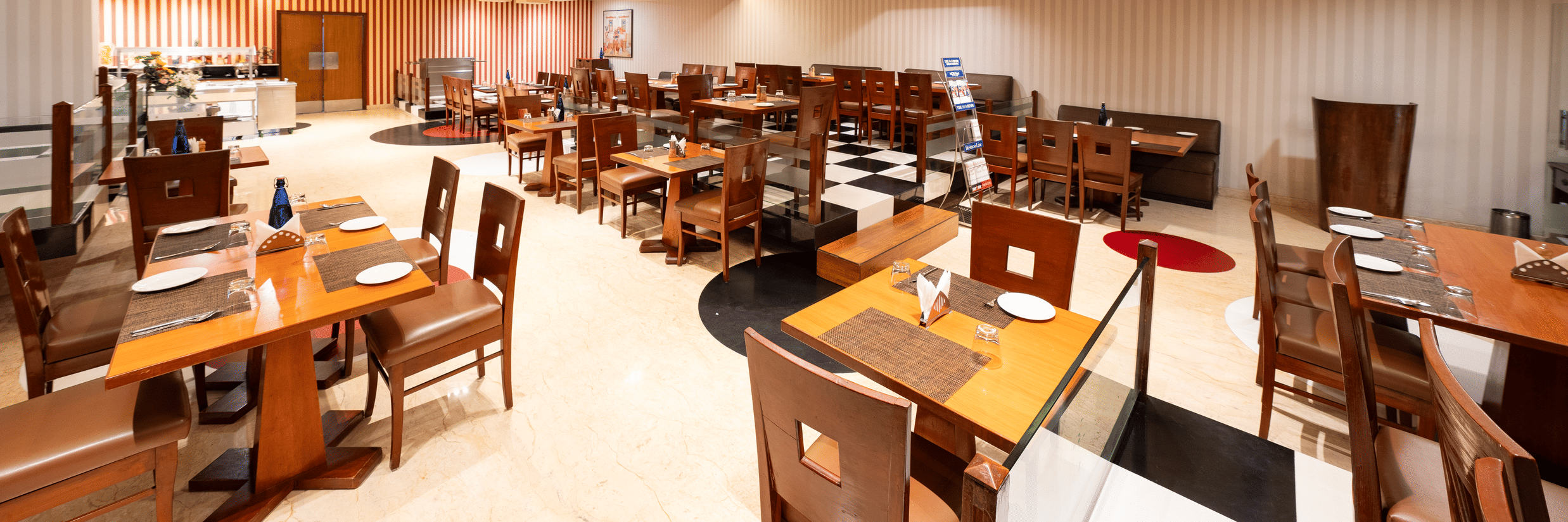 A dining space at MGM Mark Whitefield, featuring chairs, tables, and checkered wall.