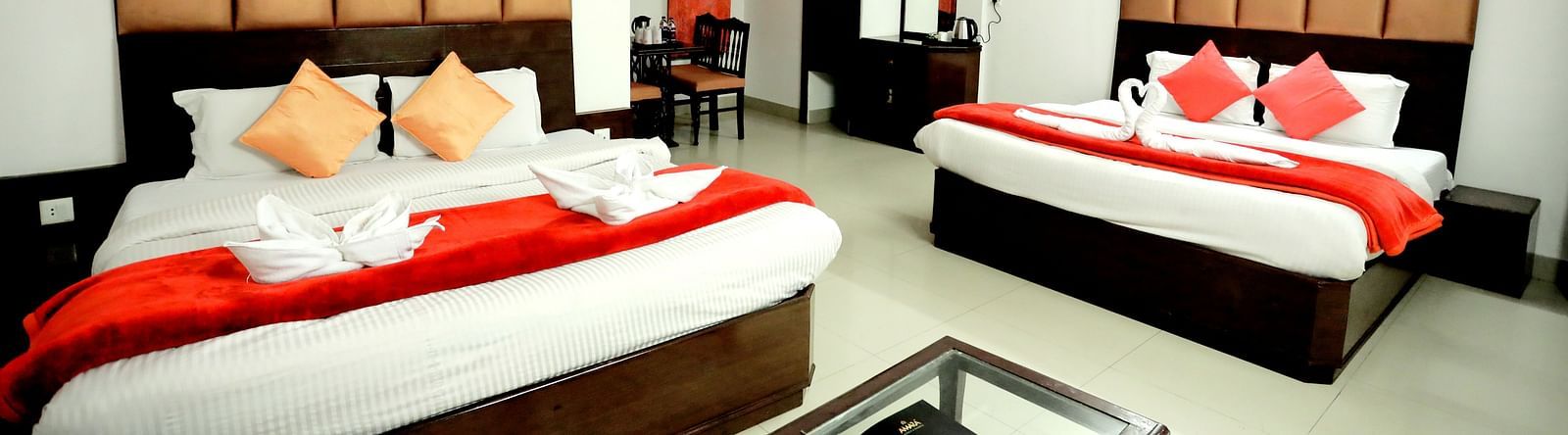 Image of a room with two beds and a table in front of the table at Amara Hill Queen, Mussoorie.