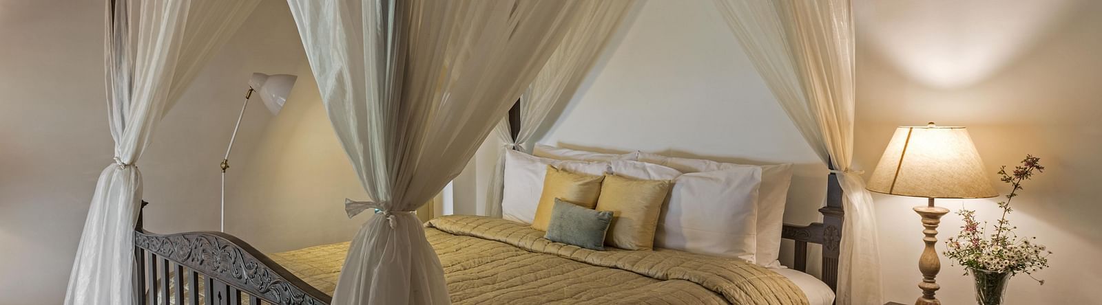 Bed with side canopy and a lamp on the side of the bed at 3 bhk cottage at Te Aroha by Shervani Mukteshwar