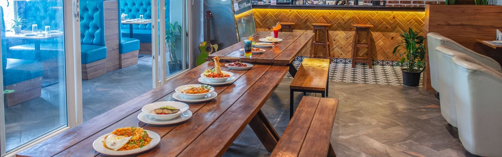 Image of a dining space space with a variety of food on a wooden table at  Avianna Ganagtok Resort and Spa