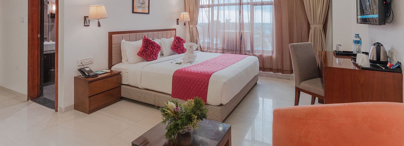 Comfortable hotel room at Diamond Palace Lords Plaza with a double bed, seating area, mounted TV, and air conditioning.