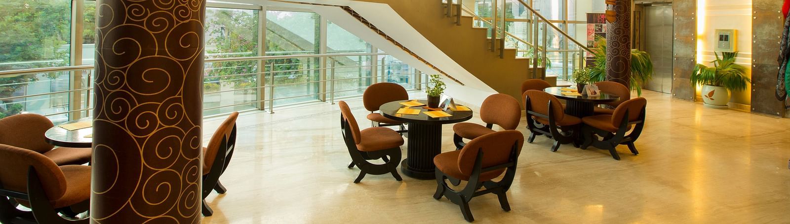 lobby of Hotel Atithi - TGI Grand, Pondicherry arrayed tables and chairs