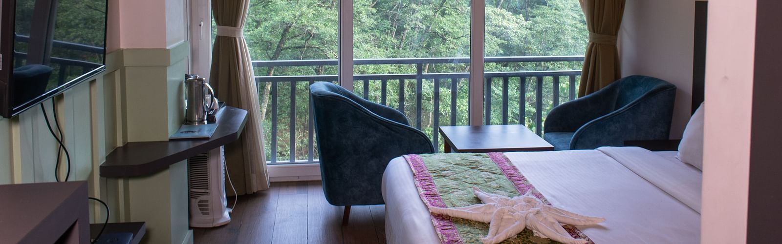 Image of premuim room with bed and sitting arrea overooking the lush greenery outside at  Avianna Ganagtok Resort and Spa