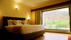 Bedroom with large window and mountain view.