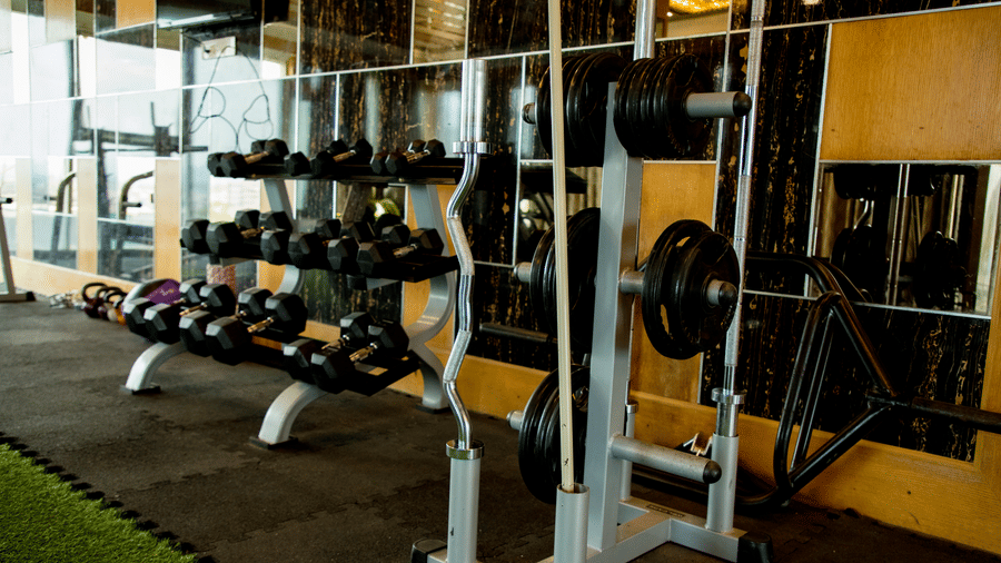 A close up shot of a rack with several dumbbells stacked on it at the Benzz Park, Vellore.