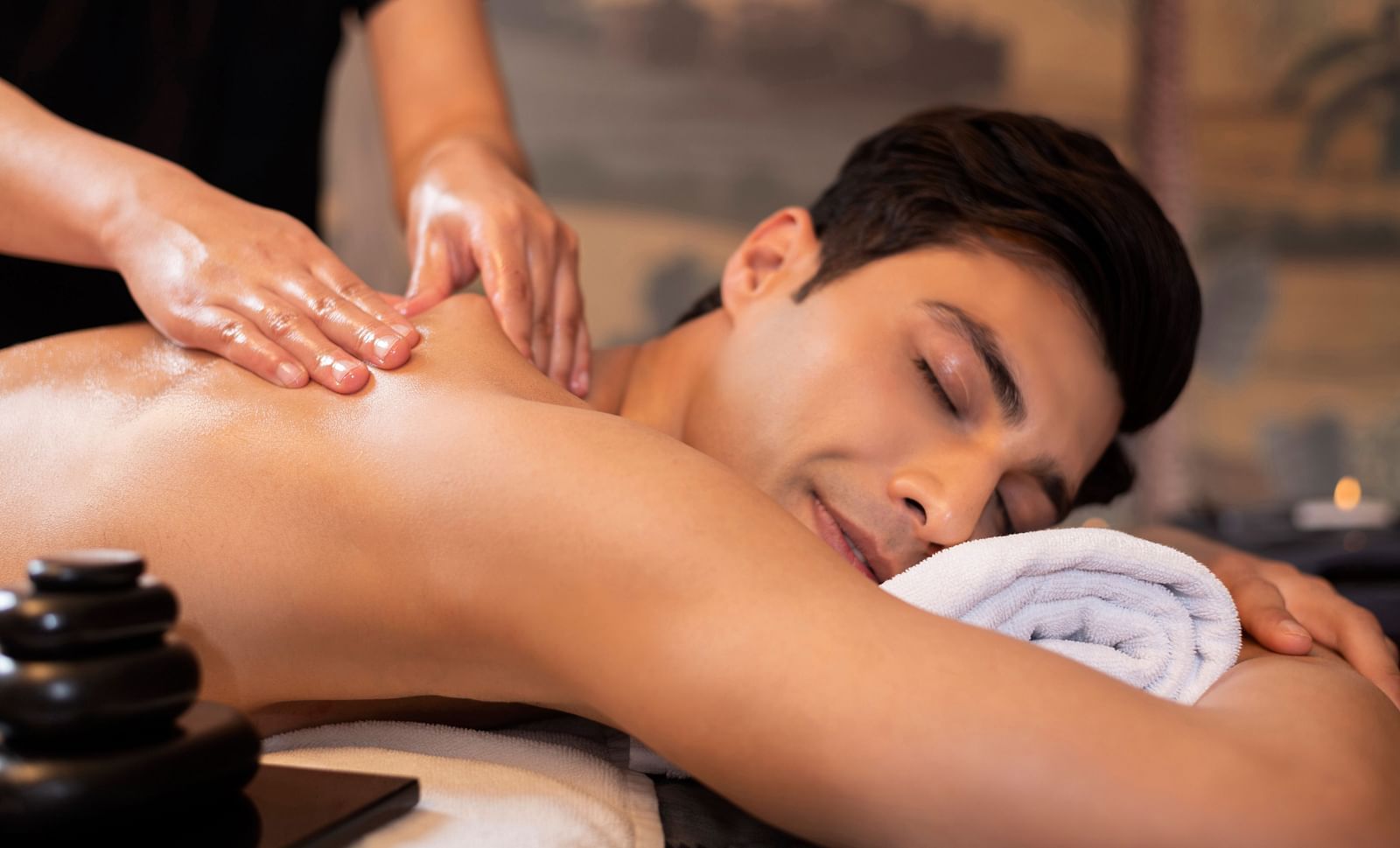 image of a man enjoying a delightful shoulder massage at the cinqtuaire spa -The Claridges New Delhi