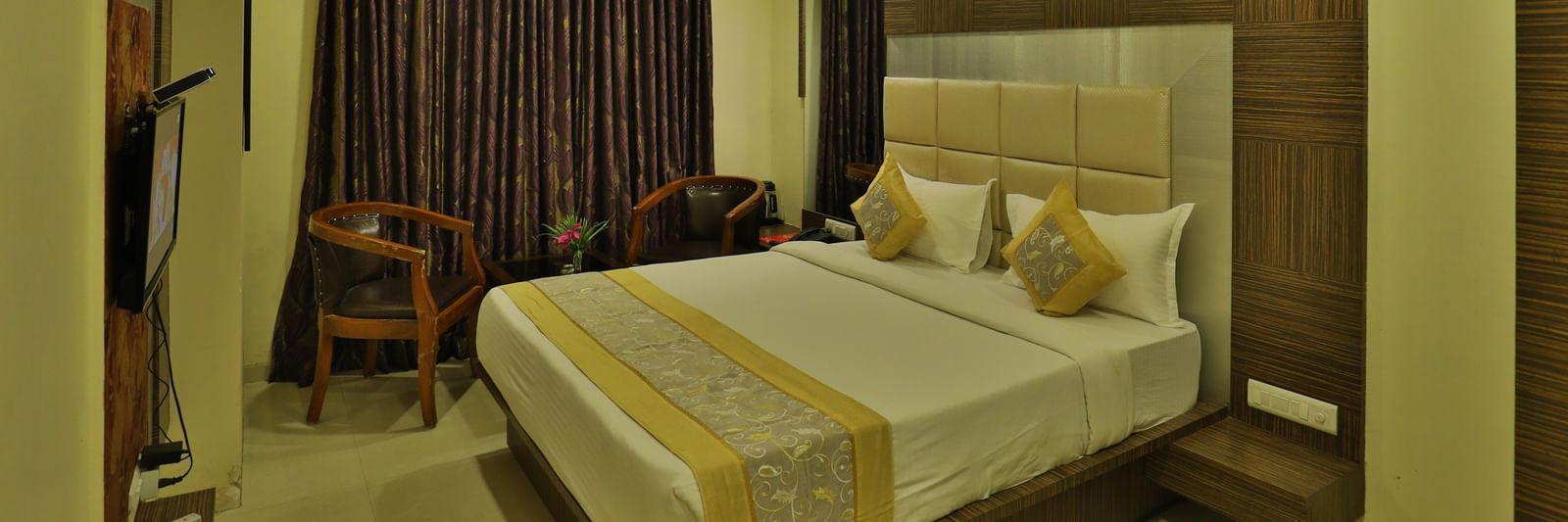 A bright hotel room with a neatly made bed, modern furniture, and warm ambient lighting - Retreat Heritage, Lonavala