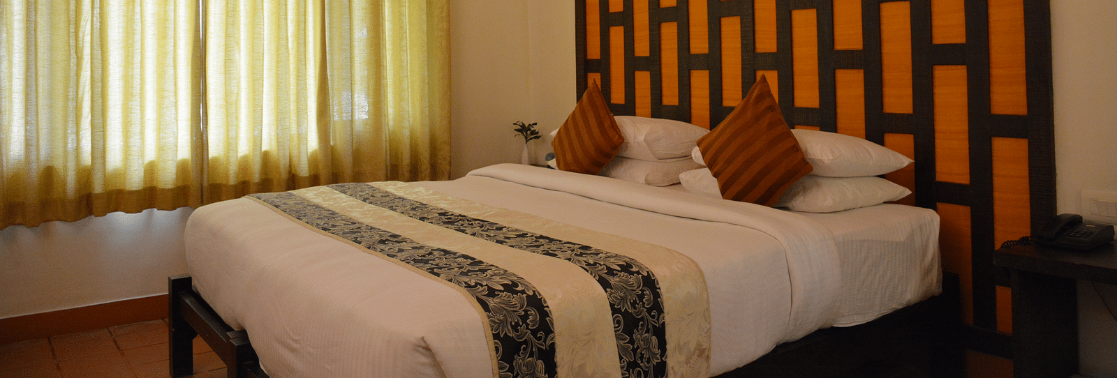 view of a bedroom with a large bed and windows covered with curtains - Kadkani River Resort, Coorg