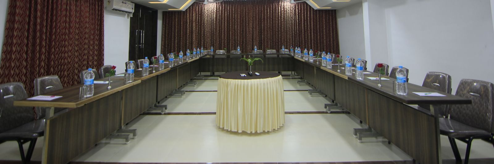 A spacious event space at Krushnai Resort with chairs and tables arranged for a conference.