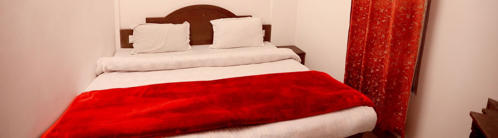 Image of a room with a bed and a window on the side at Amara Hill Queen, Mussoorie.