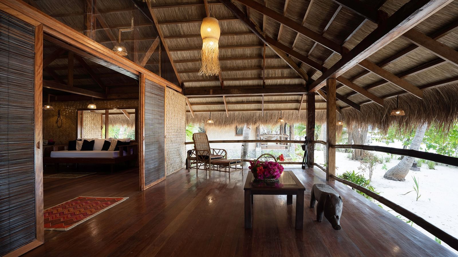 Wooden deck at Flower Island Resort with chairs and table, partially open to garden views.