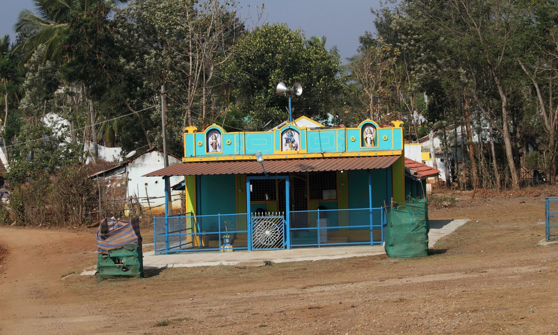 Small colorful Hindu temple in a rural setting.