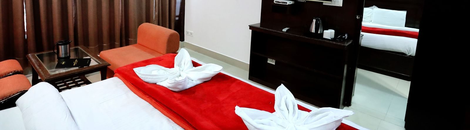 Image of a room with a bed and a door in front of it leading to another room at Amara Hill Queen, Mussoorie.