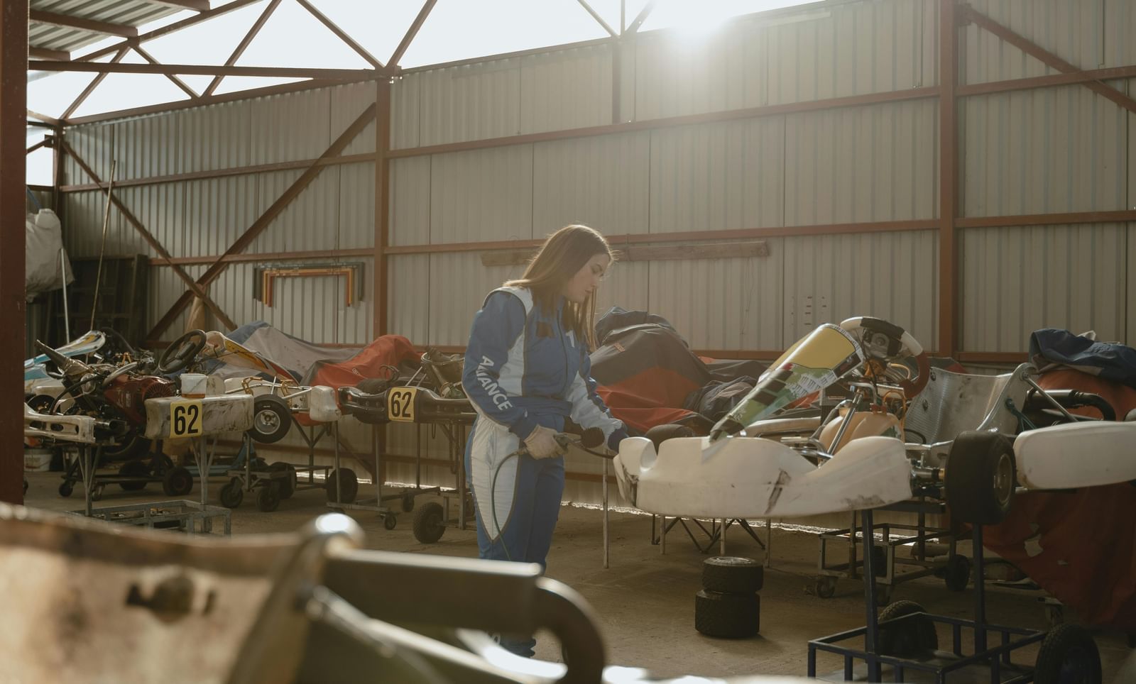 A woman inspecting karts placed on metal frames