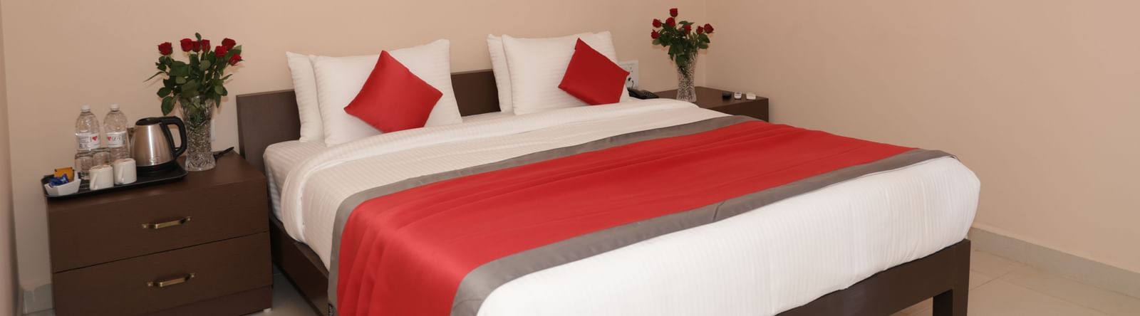 A bedroom at Nazri The Verda Hotel, Arambol, featuring a bed with cushions, bedside tables, and wall decorations.
