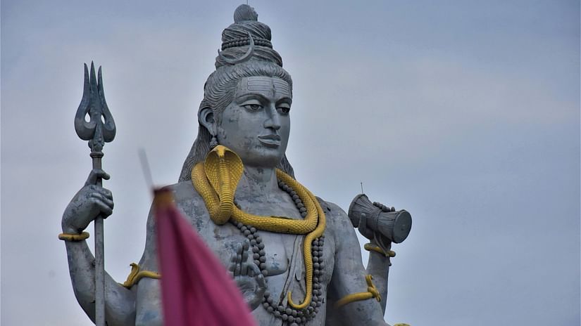 a statue of lord shiva holding a trident and damru