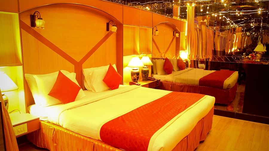  Hotel Yasodha Towers - Interior view of the bedroom containing a queen size bed with red and white coloured throw pillows and a big mirror