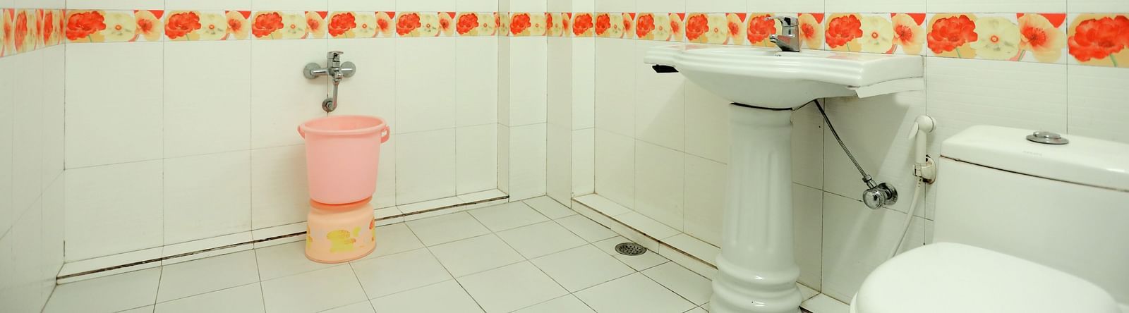 Image of a washroom with a toilet and a sink with a mirror above it at Amara Hill Queen, Mussoorie.